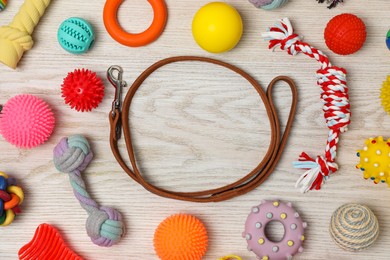 Photo of Frame made with dog leash and toys on white wooden background, flat lay. Space for text