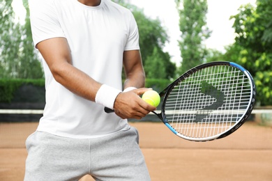 Sportsman preparing to serve tennis ball at court, closeup