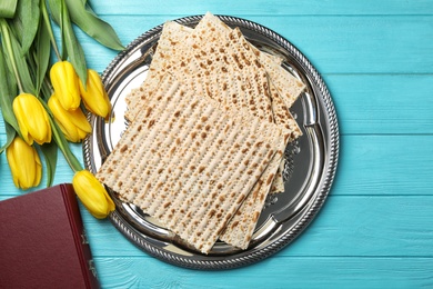 Flat lay composition of matzo, Torah and flowers on wooden background. Passover (Pesach) Seder