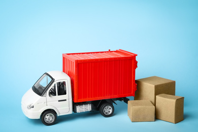 Toy truck with boxes on blue background, space for text. Logistics and wholesale concept