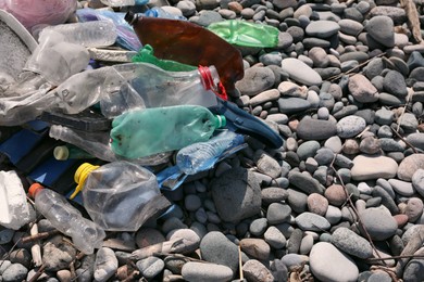 Pile of garbage on stones outdoors, closeup. Environmental Pollution concept
