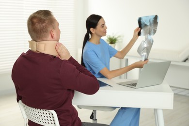 Doctor with neck MRI images consulting patient in clinic, space for text