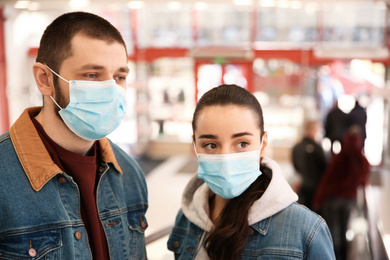 Couple wearing disposable masks in mall. Dangerous virus