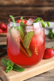 Photo of Spicy strawberry cocktail with jalapeno and mint on wooden table, closeup