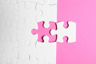 Blank white puzzle with separated piece on pink background, flat lay