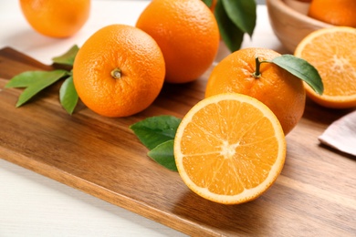 Many delicious ripe oranges on wooden board