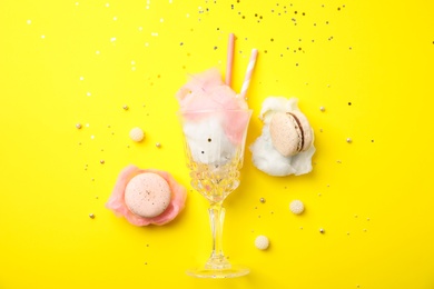 Flat lay composition with sweet cotton candy on yellow background