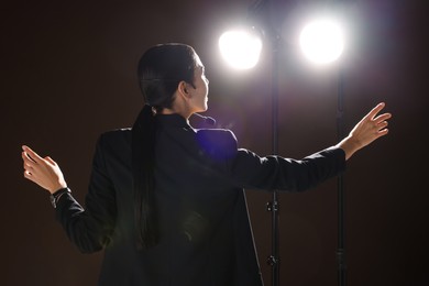 Photo of Motivational speaker with headset performing on stage, back view
