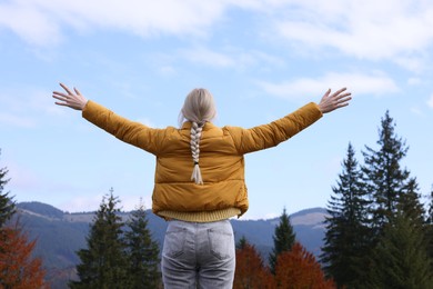 Photo of Happy woman in peaceful mountains, back view. Feeling freedom