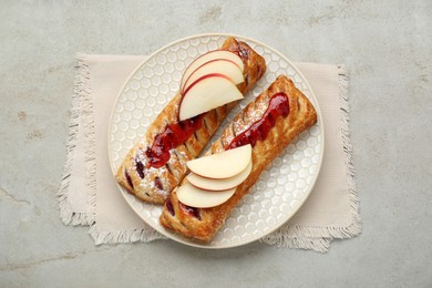 Photo of Fresh tasty puff pastry with jam and apples on white textured table, top view