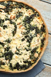 Photo of Delicious homemade spinach quiche on rustic wooden table, top view