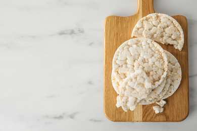 Puffed rice cakes on white wooden table, top view. Space for text