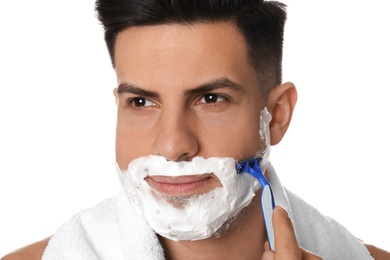 Handsome man shaving with razor on white background, closeup