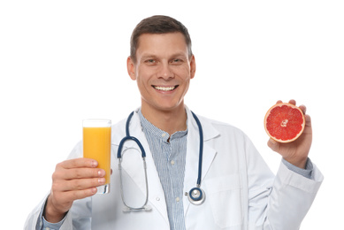 Nutritionist with glass of juice and grapefruit on white background