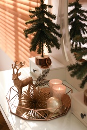 Composition with decorative reindeer and Christmas trees on dressing table
