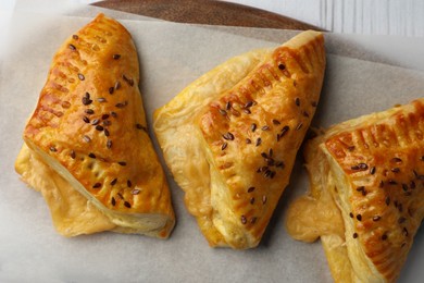 Photo of Fresh delicious puff pastry on parchment, top view