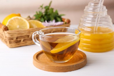 Photo of Cup of delicious tea with lemon and honey on white table