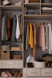 Wardrobe closet with different stylish clothes, accessories and shoes