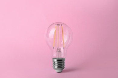 Vintage filament lamp bulb on pink background