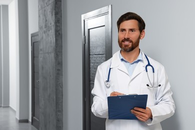 Doctor in white coat with stethoscope and clipboard indoors. Space for text