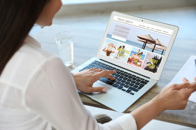 Image of Woman using laptop to plan trip, closeup. Travel agency website