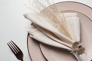 Photo of Plates with fabric napkin, decorative ring and fork on white marble table, flat lay