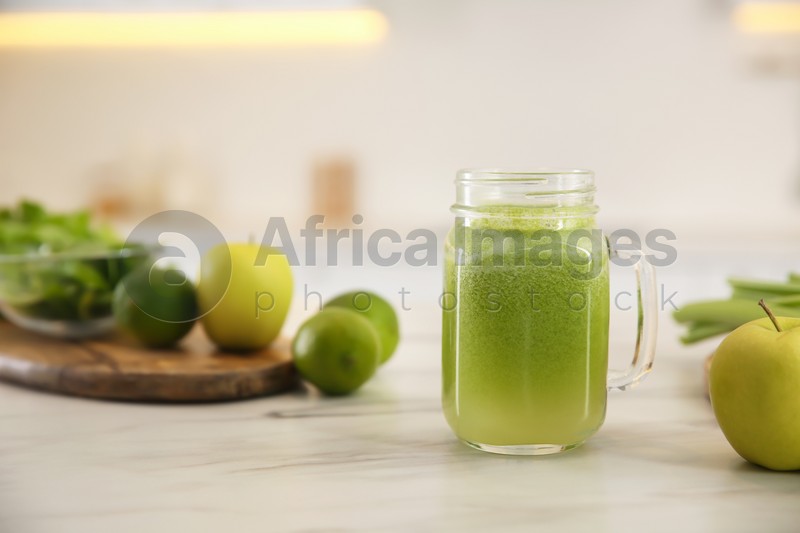 Photo of Tasty fresh juice in mason jar on table indoors. Space for text