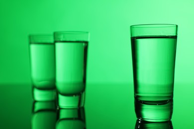 Vodka on table against green background, space for text