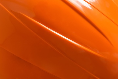 Orange plastic material as background, top view