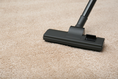 Removing dirt from carpet with modern vacuum cleaner indoors, closeup