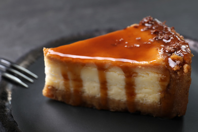 Piece of delicious cake with caramel on plate, closeup