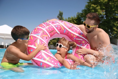 Father and children having fun in swimming pool. Family vacation