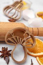 Cookie cutters and rolling pin on white table, closeup