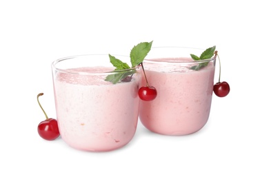 Tasty fresh milk shakes with cherries on white background