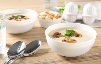 Delicious cream soup with mushrooms on wooden table