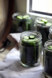 Photo of Glass jar with fresh cucumbers on table, closeup. Canning vegetables