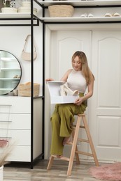 Woman with boots sitting on ladder indoors. Interior design