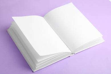 Open book with blank pages on violet background
