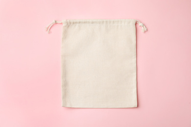 Photo of Cotton eco bag on pink background, top view