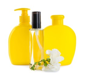 Baby oil, toiletries and flowers on white background