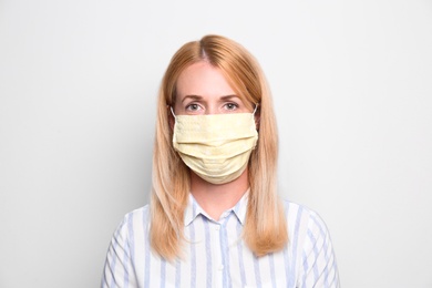 Woman wearing handmade cloth mask on white background. Personal protective equipment during COVID-19 pandemic
