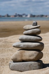 Stack of stones on beautiful sandy beach near sea