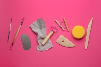 Photo of Set of clay modeling tools on pink background, flat lay