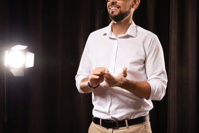 Photo of Motivational speaker with headset performing on stage, closeup. Space for text
