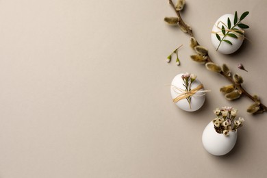 Photo of Flat lay composition with chicken eggs and floral decor on light grey background, space for text. Happy Easter