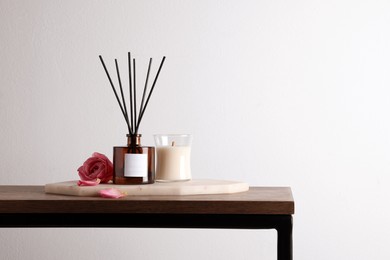 Composition with aromatic reed air freshener on wooden table, space for text