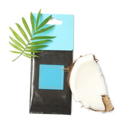 Scented sachet, green leaf and piece of coconut on white background, top view