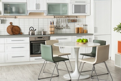 Photo of Stylish kitchen interior with dining table and chairs