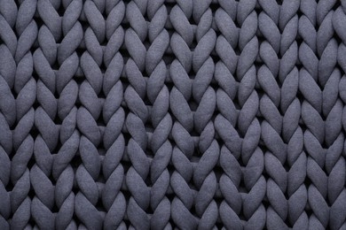 Top view of grey chunky knit blanket as background