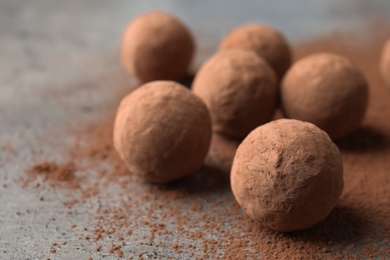 Delicious raw chocolate truffles on grey background, space for text
